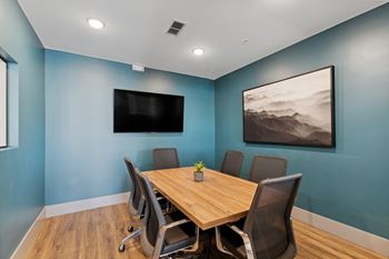 a conference room with a table and chairs and a flat screen tv on the wall